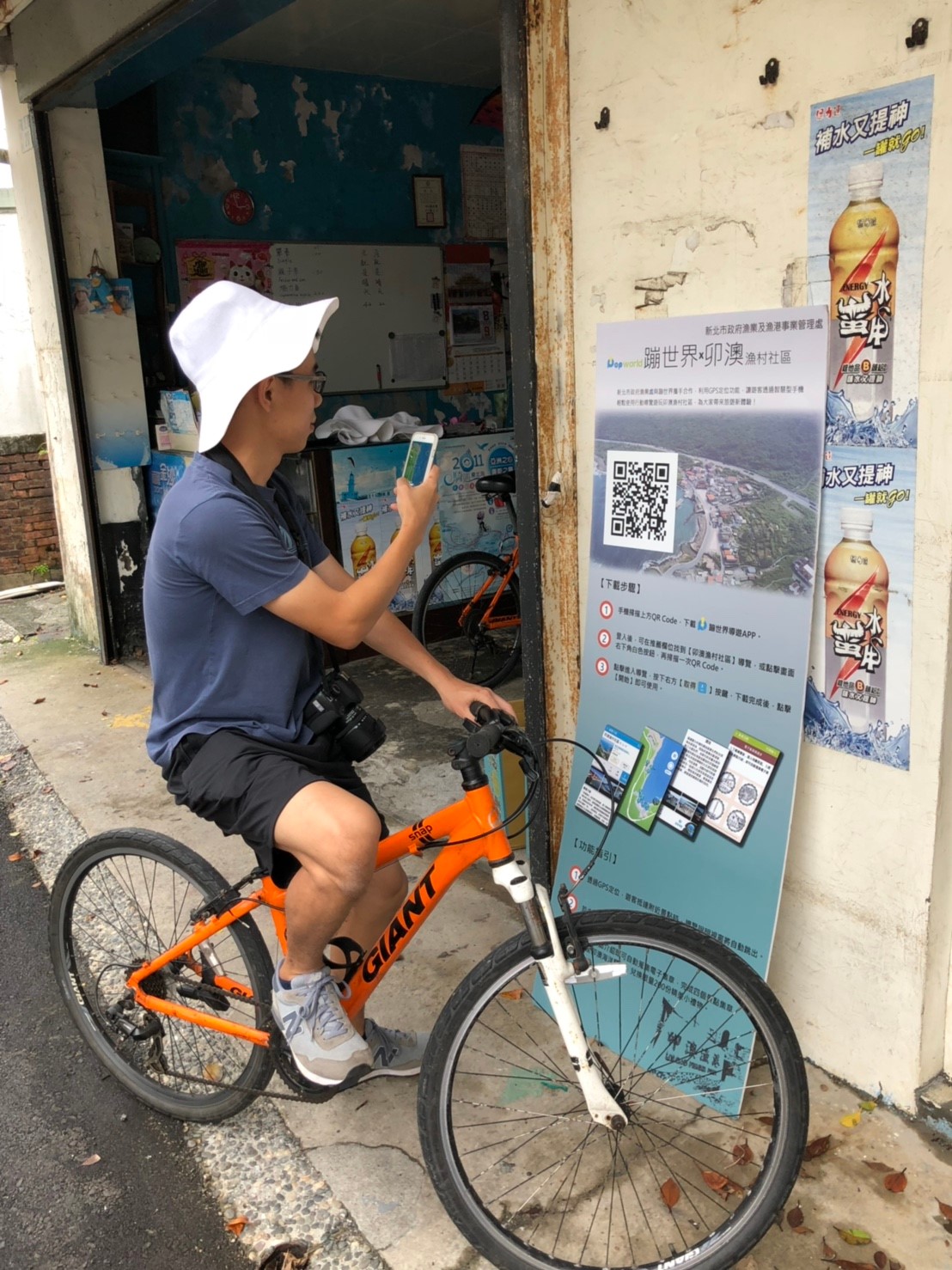 遊客在福隆自行車店外下載卯澳漁村行動導覽APP